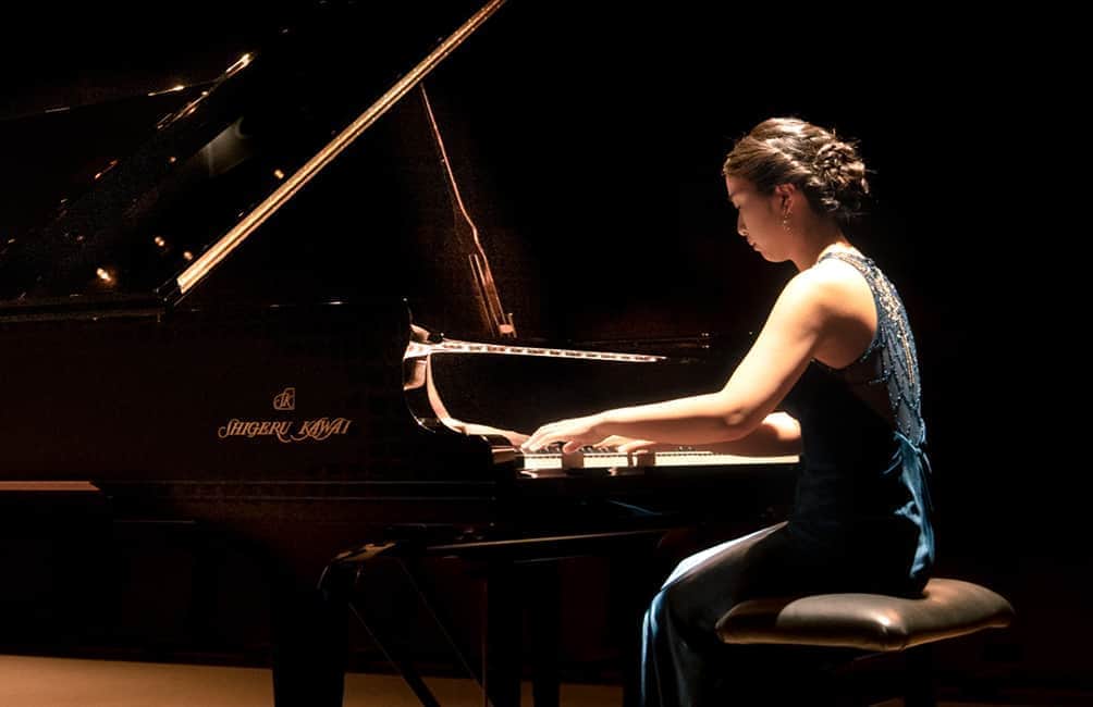 ピアノを弾いている横向き女性